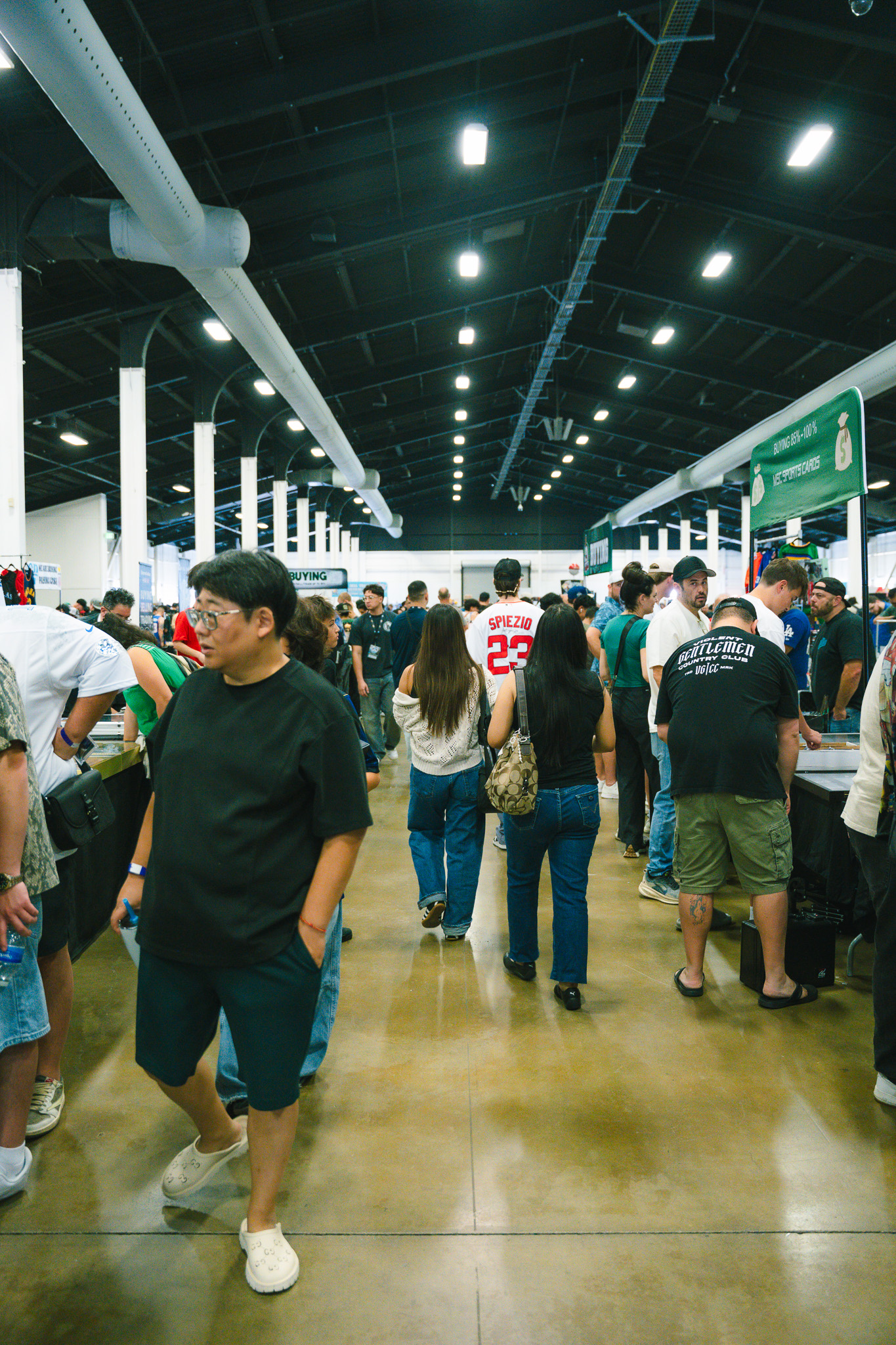 Attendees walking down a crowded aisle lined with vendor booths on the show floor